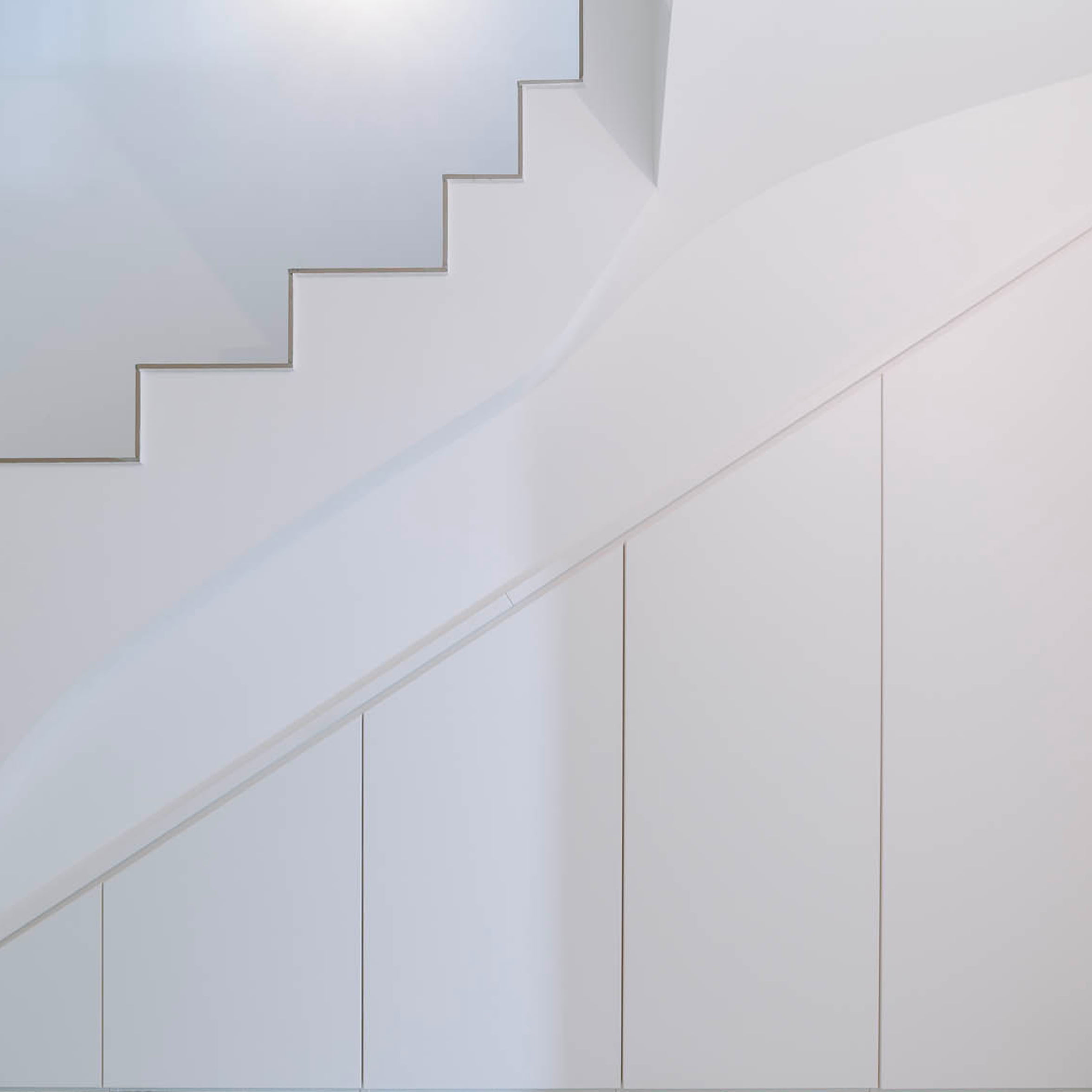 Placard sur mesure aménagé sous un escalier blanc
