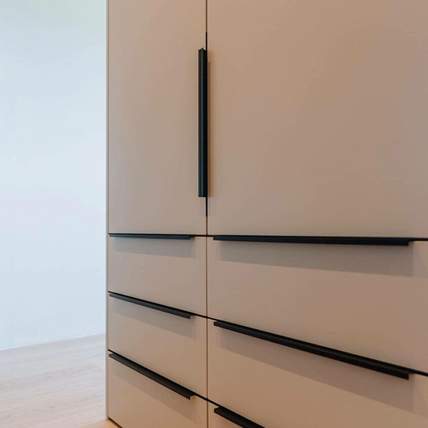 Aménagement d'un dressing gris dans un couloir attenant à une chambre au Luxembourg