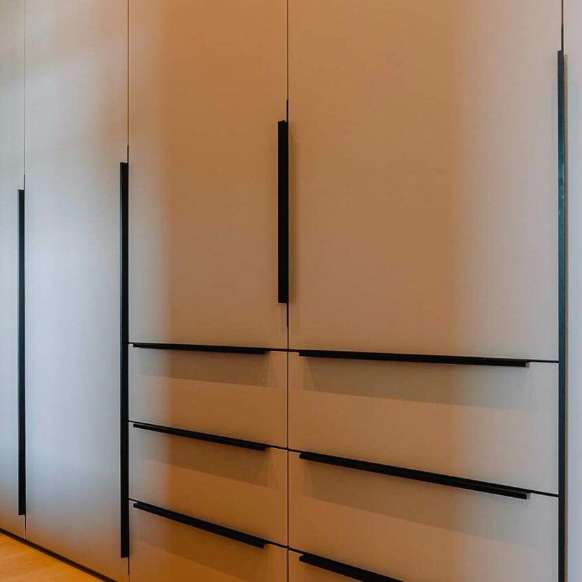 Aménagement d'un dressing gris dans un couloir attenant à une chambre au Luxembourg