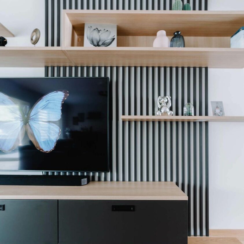 Meuble TV sur mesure claustra noir et panneaux en bois clair réalisé par BeHome Interiors Luxembourg