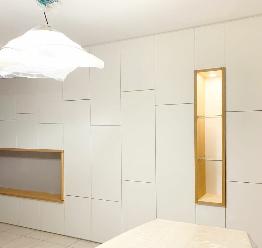 Agencement d'un mur de rangement blanc avec niche en bois de chêne dans un salon