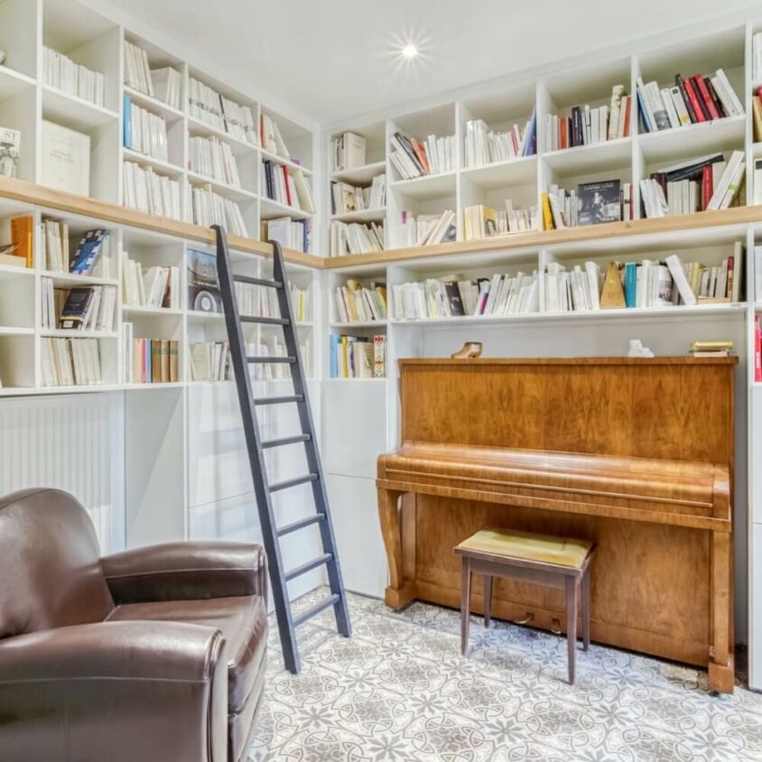 Bibliothèque d'angle intégrant un piano et avec une échelle