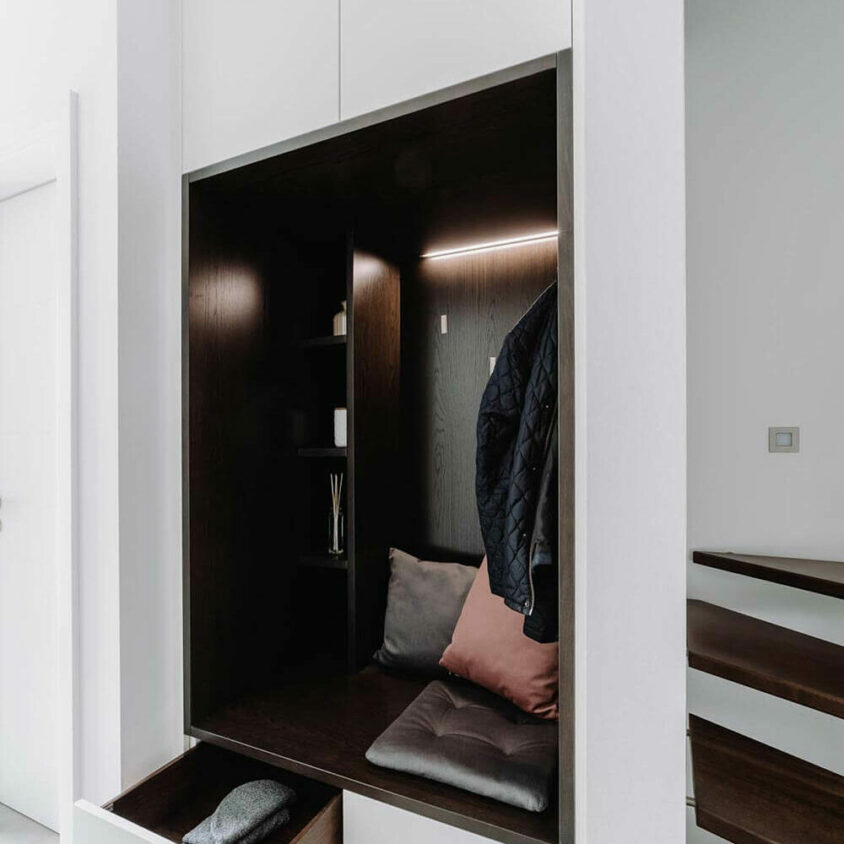Aménagement d'une entrée à Paris avec un meuble placard blanc et niche bois sombre