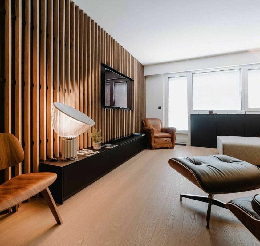 Aménagement d'un salon avec meuble bas noir et lambris en bois