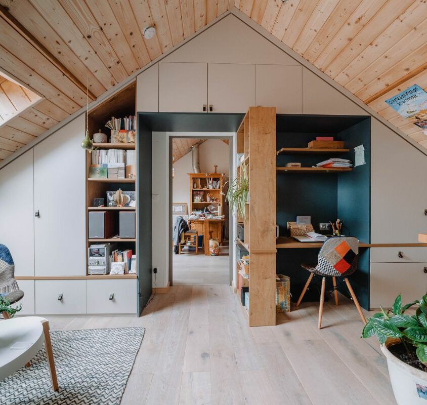 Aménagement d'une chambre sous pente avec mur de rangement et bureau intégré