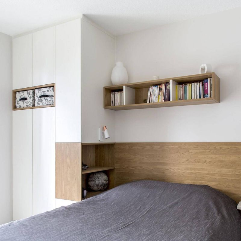 Aménagement d'une petite chambre avec armoire et tête de lit intégrée couleur blanc et bois clair