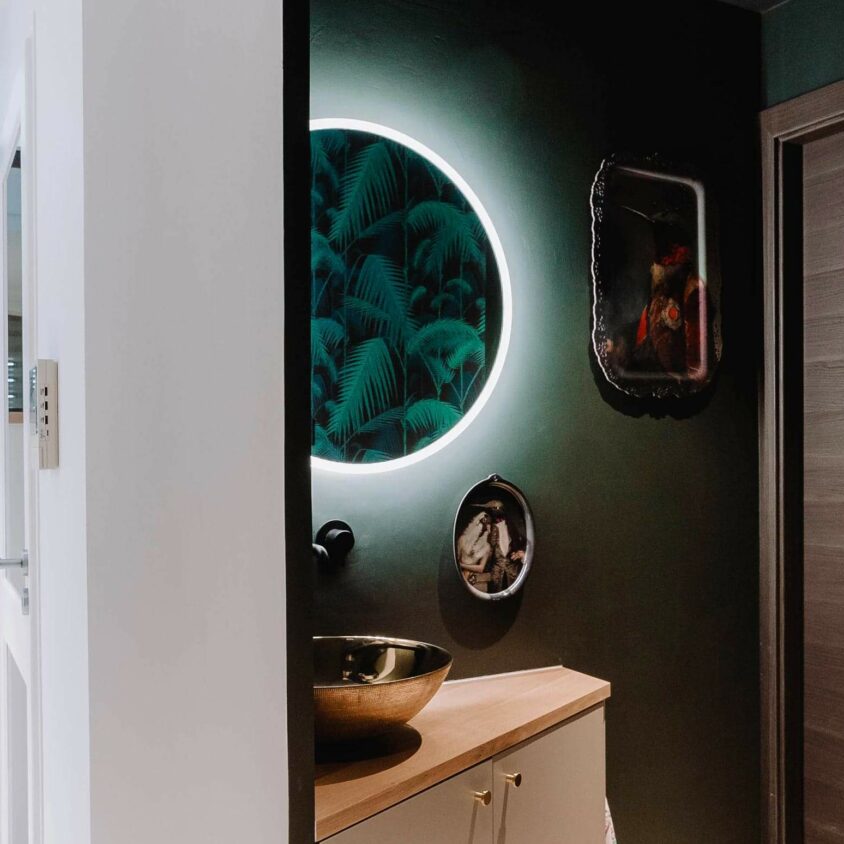 Détail d’un miroir LED avec lavabo et armoire dans un coin salle de bain