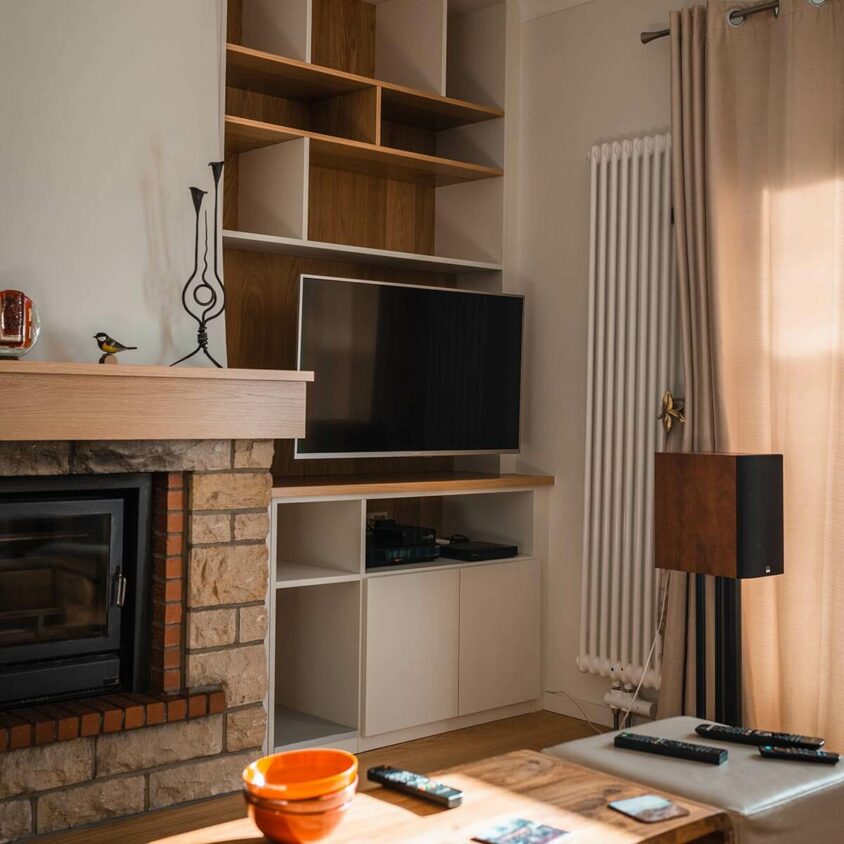 Meuble sur-mesure intégrant une TV réalisé autour d'une cheminée lors d'une rénovation de salon au Luxembourg