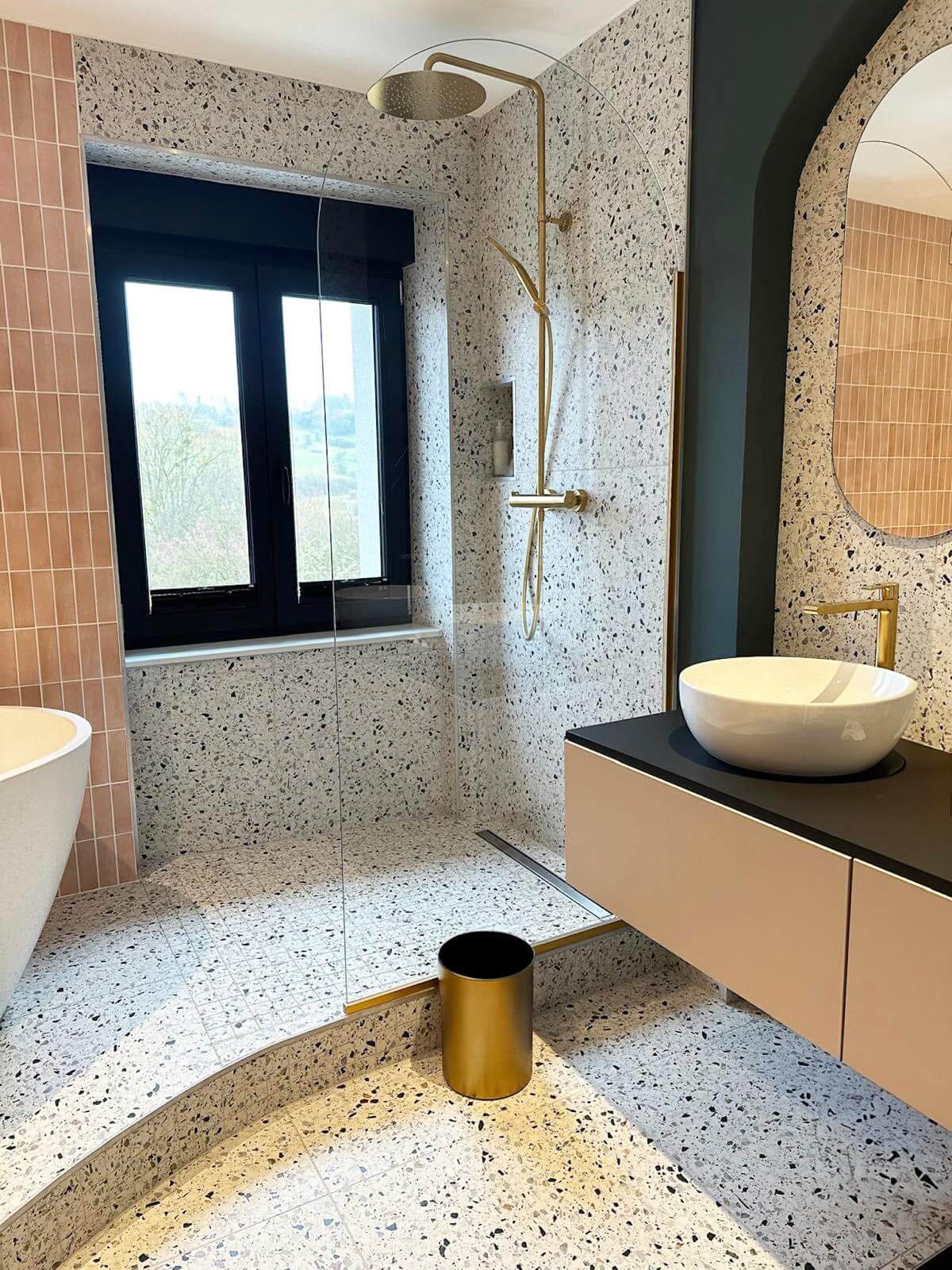 Salle de bain moderne avec matériaux haut de gamme, terrazzo, robinetterie dorée et vasque design