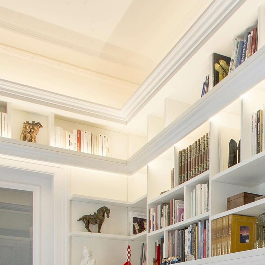 Bibliothèque sur mesure blanche avec éclairage en angles réalisée à Howald Hesperange par BeHome Interiors Luxembourg