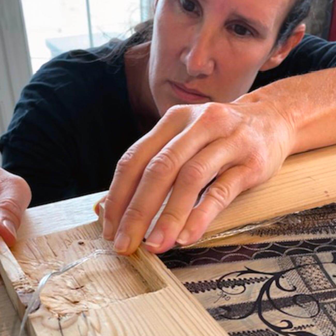 Christelle Diebold-Christinaz, artiste Sweet Rock, ajuste les éclairages LED intégrés à l’un de ses cadres en bois inspirés de la Poya.