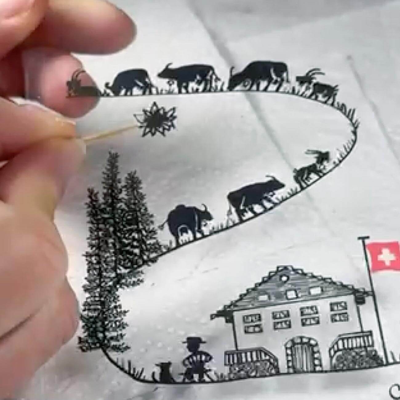 Gros plan sur Christelle Diebold-Christinaz, artiste fribourgeoise derrière Sweet Rock, concentrée sur la peinture minutieuse d’une Poya.