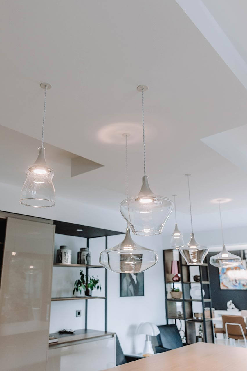 Aménagement d'intérieur global de maison à Bussigny près de Genève avec luminaires verre entre cuisine et salon