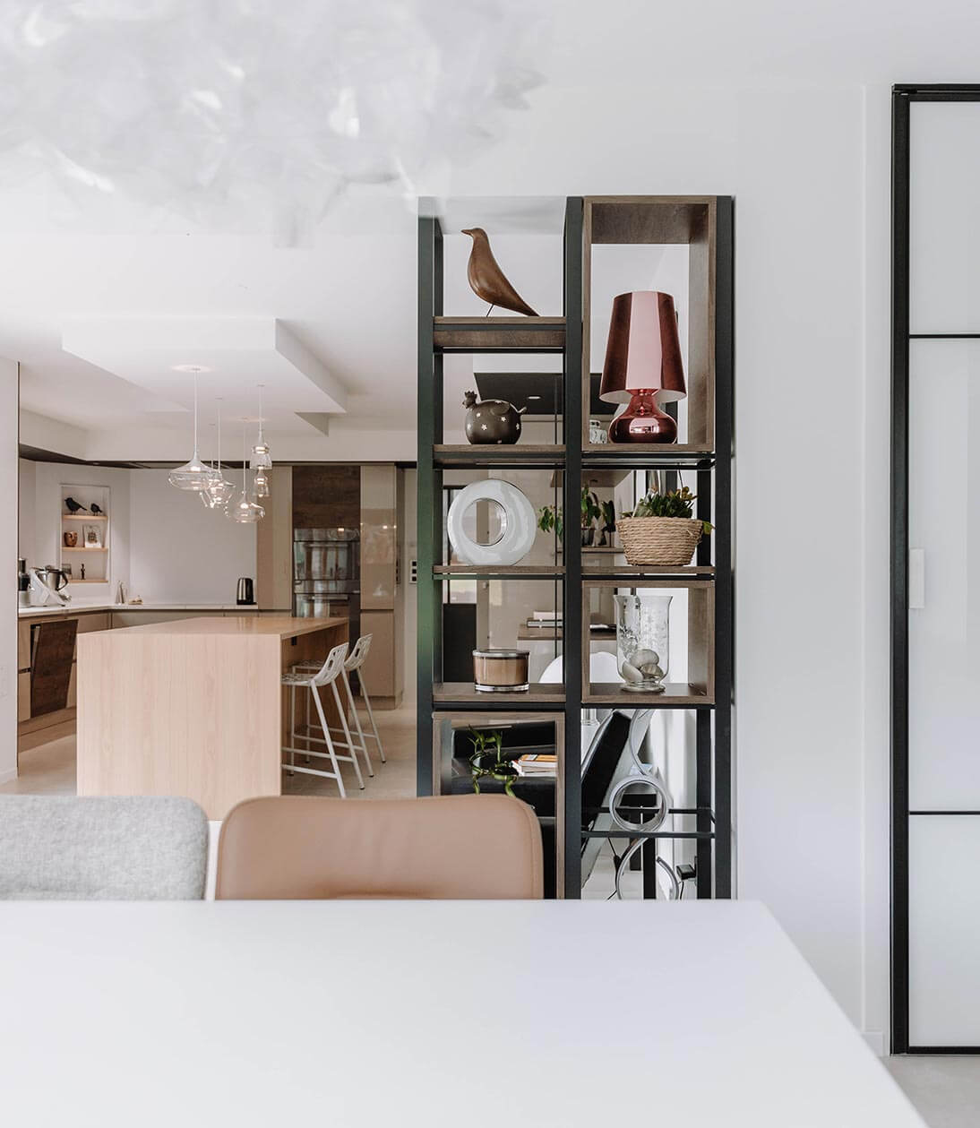 Aménagement d'intérieur global de maison à Bussigny près de Genève, vue sur étagère sur mesure depuis le salon