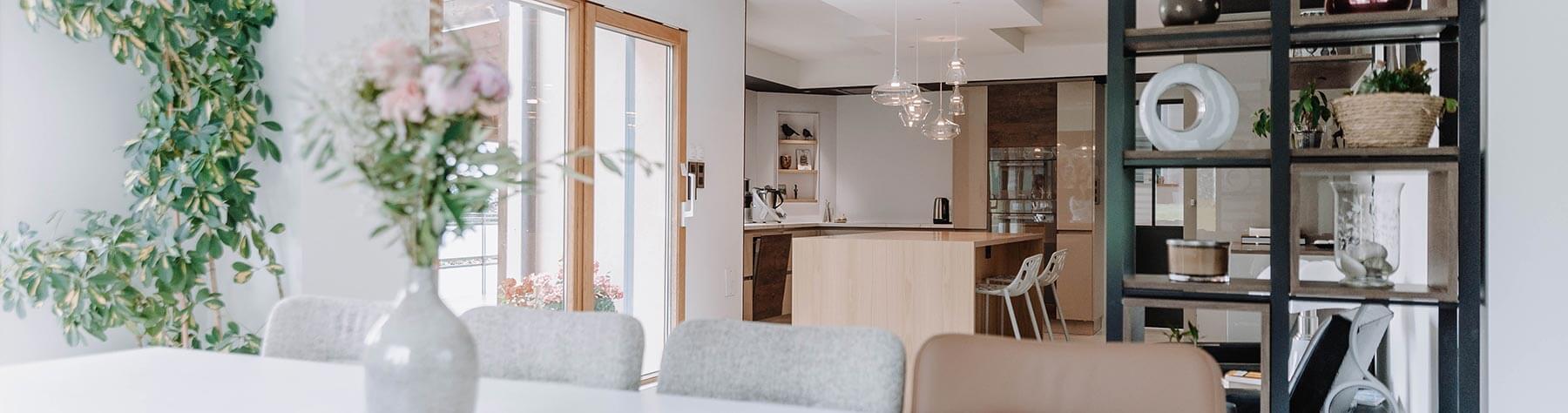Aménagement d'intérieur global de maison à Bussigny près de Genève, vue sur étagère sur mesure et cuisine depuis le salon