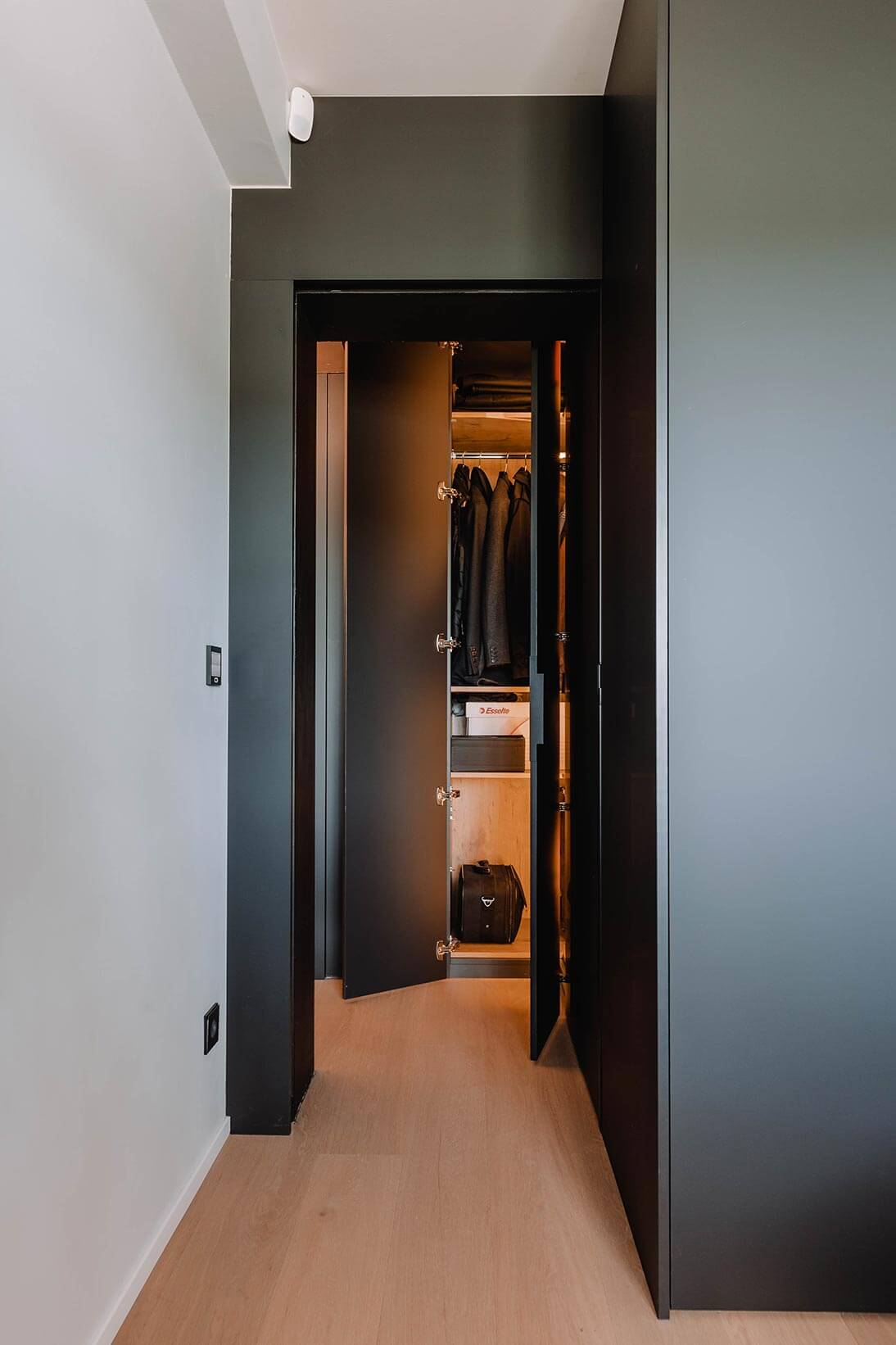 Aménagement global d'un appartement à Luxembourg avec mobilier noir et armoire éclairée
