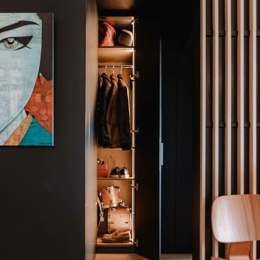 Aménagement global d'un appartement à Luxembourg avec mobilier noir comme cette armoire éclairée