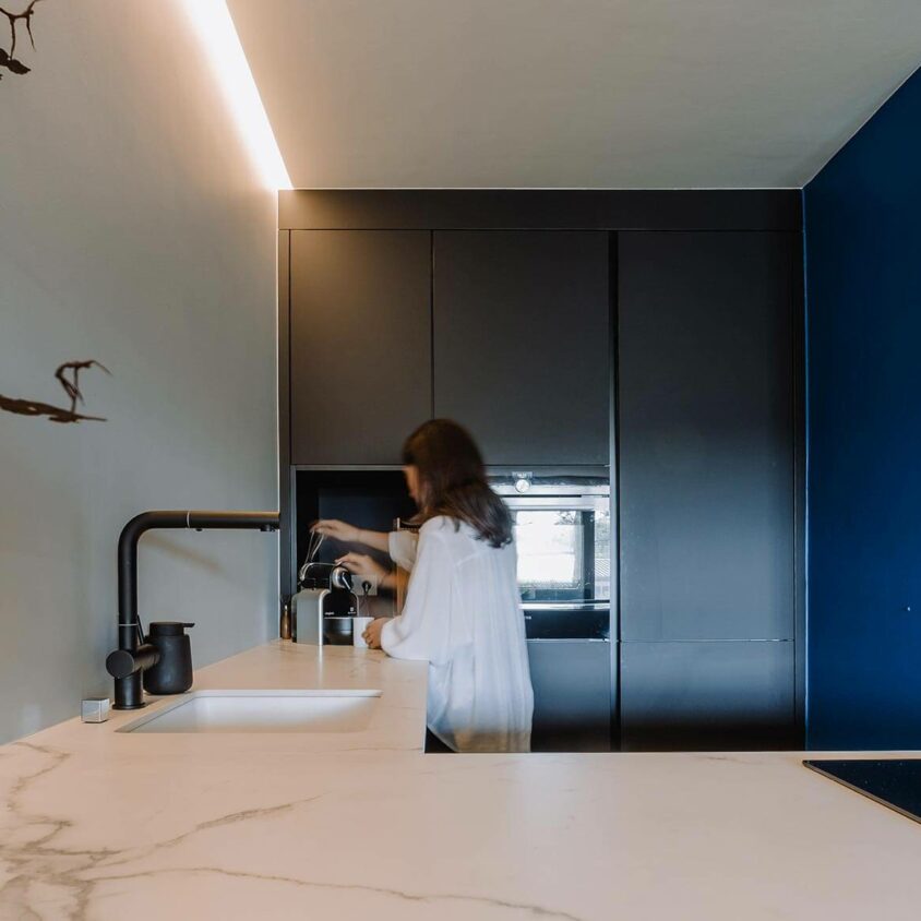 Aménagement de cuisine sur mesure noire à Luxembourg, ouverte sur un salon