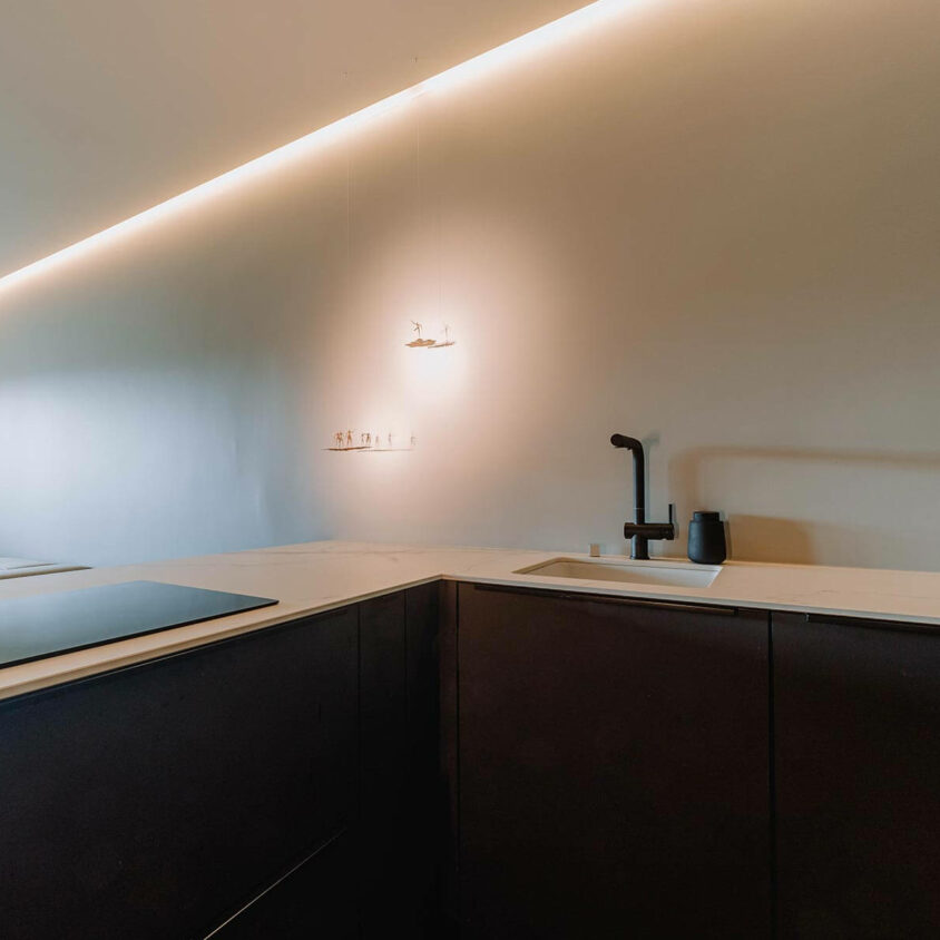 Aménagement de cuisine sur mesure noire à Luxembourg, avec éclairage indirect