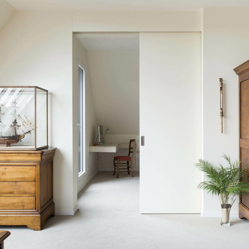 Aménagement global d'appartement atypique blanc à Genève avec porte coulissante
