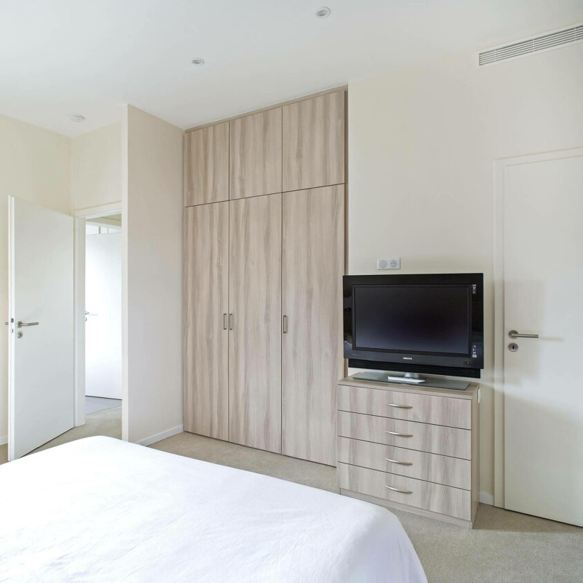 Aménagement global d'une chambre avec placard dans un appartement atypique blanc à Genève