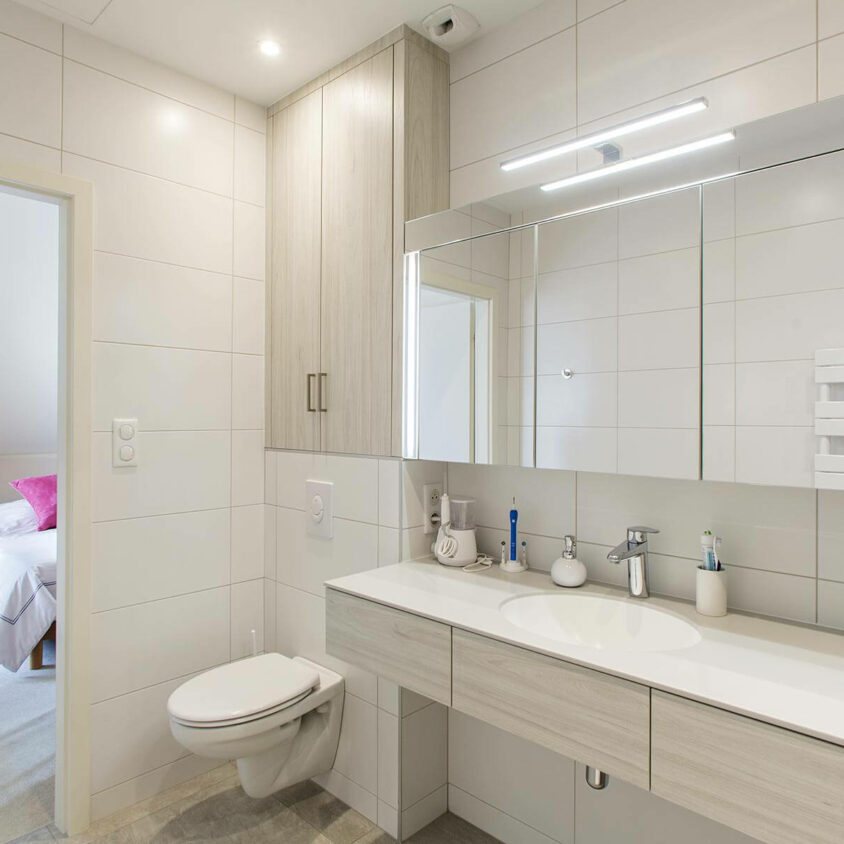 Aménagement global d'appartement atypique blanc à Genève avec salle de bain sur mesure
