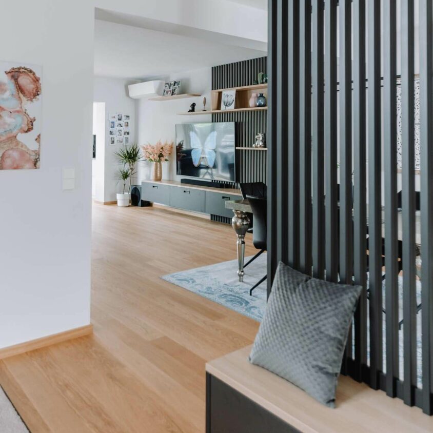 Aménagement global du rez-de-chaussée d'une maison à Luxembourg incluant l'entrée et le salon avec claustra noir