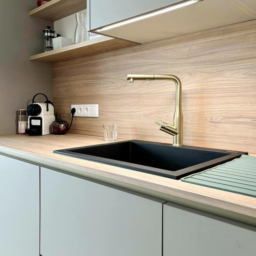 Aménagement intérieur d'un studio destiné à la location meublée avec lavabo et robinet doré