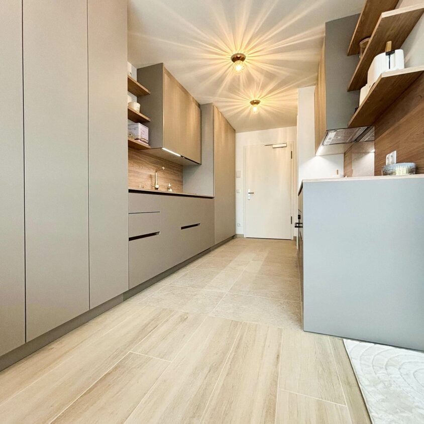 Aménagement intérieur d'un studio destiné à la location meublée avec longs meubles de rangements et cuisine